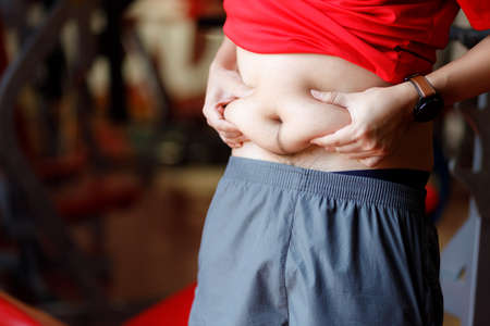 Fit young woman lifting barbells looking focused, working out in a gym.の写真素材