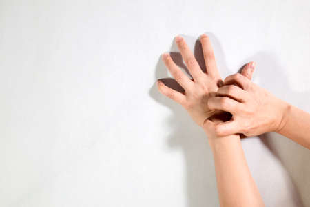 Woman hand scratching on feet isolated on white background for healthy concept.