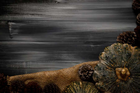 Fall Thanksgiving and Halloween pumpkins, leaves, acorn squash over dark wood table background shot from directly above.の写真素材