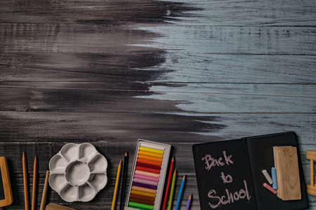 School supplies on black board background. Back to school concept.