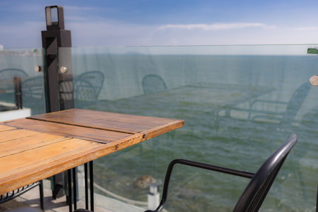 Summer terrace with stylish trendy outdoor furniture at a luxurious travel destination. Wooden desk of free space and summer background of beach.の写真素材