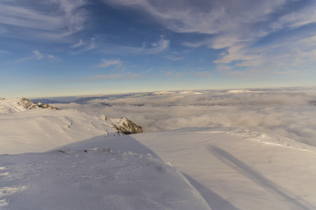 peaks of mountains above the clouds. Winter landscape