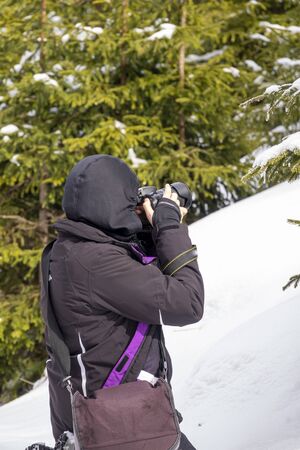 Woman Photographer Hiker In Snowy Mountain, In Search Of Best Picture to Takeの写真素材