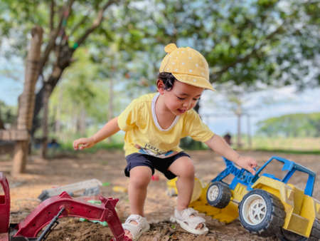 Asian boy, 2 years old, playing with old toys happily playing on the ground. on weekends of the week Schoolâs Out for Summerの写真素材