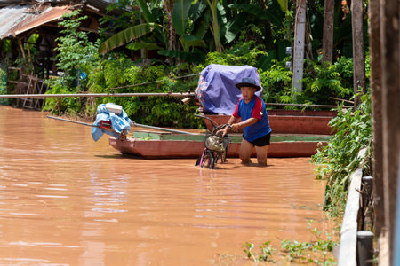 August 14, 2022 Nan ââThailand - Flooded roads, cars drive through floodwaters to go ahead. The impact of depression Mulanのeditorial素材
