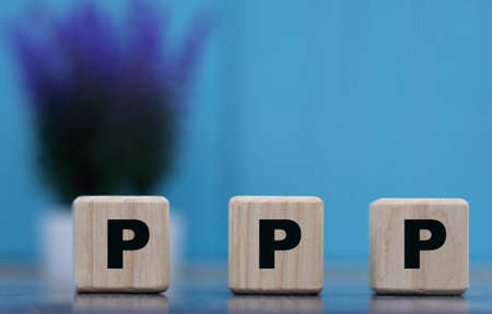 PPP - word on cubes on a blue background with lavender. Business and technology conceptの写真素材