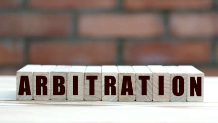 concept word arbitration on cubes against the background of a brick wall