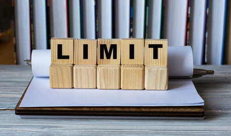 LIMIT - word on wooden cubes in a notebook on the background of books. Info conceptの写真素材