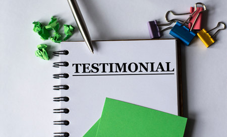 TESTIMONIAL - words in a notebook with stationery clips, pen and green papers. Business and finance conceptの写真素材
