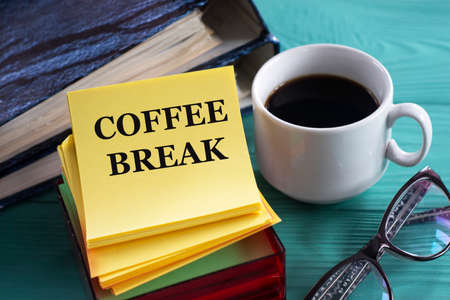 COFFE BREAK - words on yellow note sheets on a green background with a cup of coffee, glasses and folders. Business conceptの写真素材