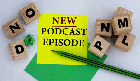 NEW PODCAST EPISODE - words on yellow note paper on light background with wooden cubes.Info conceptの写真素材