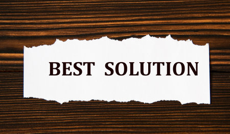 BEST SOLUTION - word on a white tattered piece of paper on a wooden background. Info conceptの写真素材