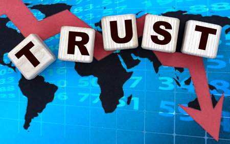 TRUST word on cubes on blue chart with red arrow down. Business concept.
