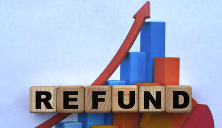 concept word REFUND on cubes against the background of the graph. Business concept.の写真素材