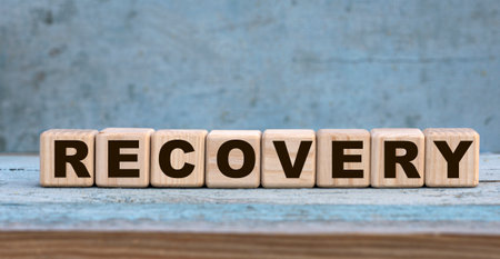 RECOVERY word on cubes on an old gray background with cactus. Business concept.の写真素材