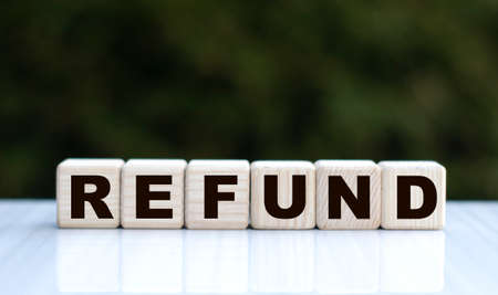 The concept of the word REFUND on cubes on a beautiful green background. Business concept.の写真素材