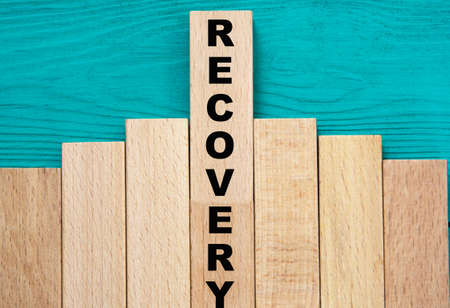 RECOVERY - word on wooden bars on a green background. Info conceptの写真素材