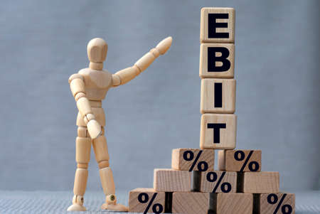 EBIT, the word is on cubes on a gray background, next to it is a wooden man.の写真素材