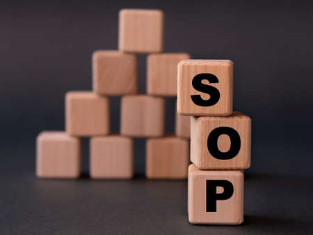 SOP (Standard Operating Procedure) - acronym on wooden cubes on a dark background. business conceptの写真素材