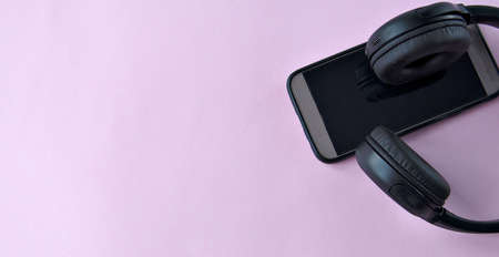 The music in the smart phone and headphones on a pink background.の写真素材