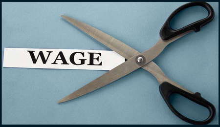WAGE - word on white paper on a gray background with open scissors. business conceptの写真素材