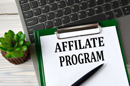 AFFILATE PROGRAM - words on a white sheet on the background of a laptop and a cactus. business conceptの写真素材