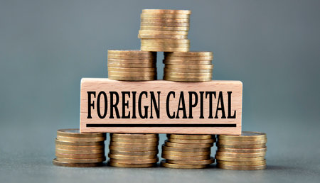 FOREIGN CAPITAL - words on a wooden bar against the background of stacks of coins. business and finance conceptの写真素材