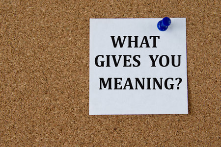 WHAT GIVES YOU MEANING? - words on a white piece of paper attached to a brown note boardの写真素材