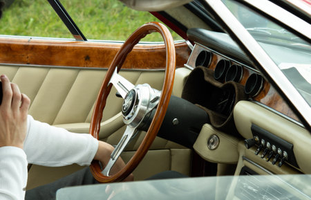 Unrecognizable man drives a retro car with a chic steering wheelの写真素材