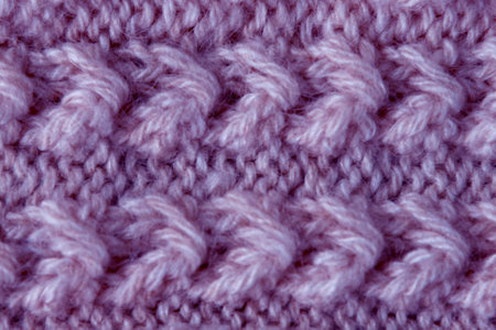The texture of the fabric of a lilac woolen sweater with a pattern. Handmade
