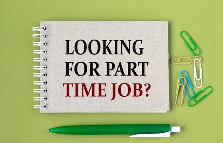LOOKING FOR PART TIME JOB? - words on a gray notebook with pen and paper clipsの写真素材