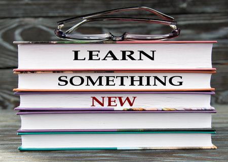 LEARN SOMETHING NEW - words are written on books on a dark background. education conceptの写真素材