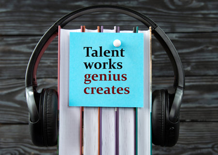 ALENT WORKS GENIUS CREATES - word on a blue piece of paper on the background of a stack of books and headphones. Freedom of Information Act conceptの写真素材