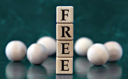 FREE - word on wooden cubes on a green background with wooden balls. Freedom of Information Act conceptの写真素材