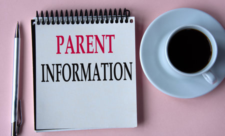 PARENT INFORMATION - words in a white notebook on the background of a cup of coffee, a pen. Soft pink background.の写真素材