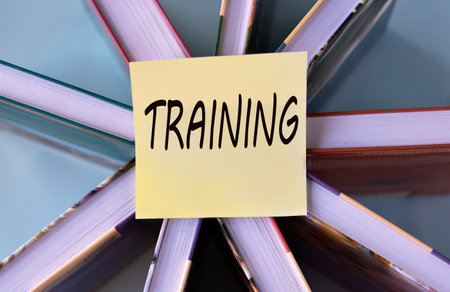 TRAINING - word on a yellow piece of paper on the background of books. Education conceptの写真素材