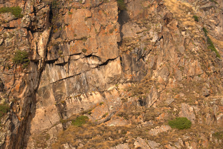 The rock is brown in color interspersed with mossの写真素材