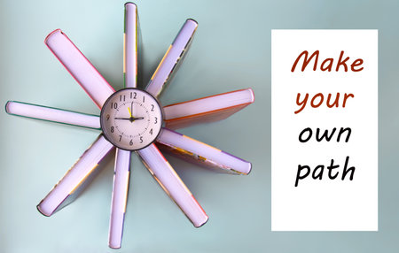 MAKE YOUR OWN PATH - words on the background of books and an alarm clock. Business conceptの写真素材