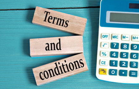 TERMS and CONDITIONS - words on wooden blocks with a calculator in the background. Business conceptの写真素材
