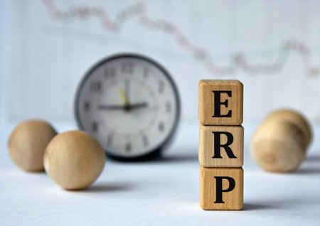 ERP (Enterprise Resource Planning) - acronym on wooden cubes on graph, clock and wooden balls background. Info conceptの写真素材