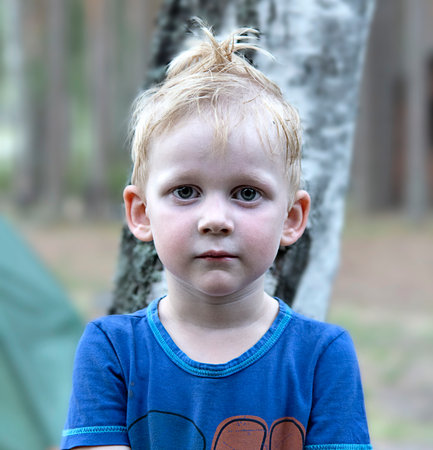 Portrait of a boy with blond hair with a funny hairstyle close-up.の写真素材