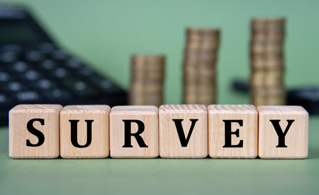 SURVEY - word on wooden cubes with calculator and coins in the background. Business conceptの写真素材