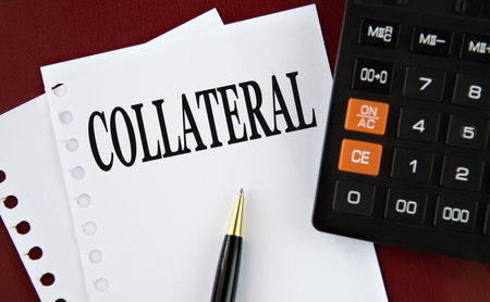 COLLATERAL - word on a white sheet with a calculator and pen in the backgroundの写真素材