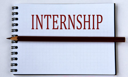 INTERNSHIP - word in white notebook on white background with pencil. Info conceptの写真素材