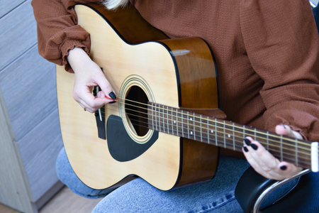 Female hands on the guitar. Close-up guitar fragment