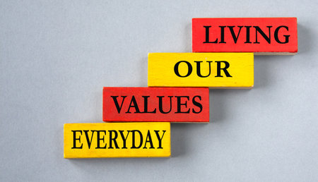 LIVING OUR VALUES EVERYDAY - words on colorful wooden blocks on a gray background