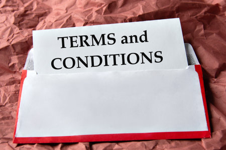 TERMS and CONDITIONS - word on a white sheet with an envelope background and crumpled red paper