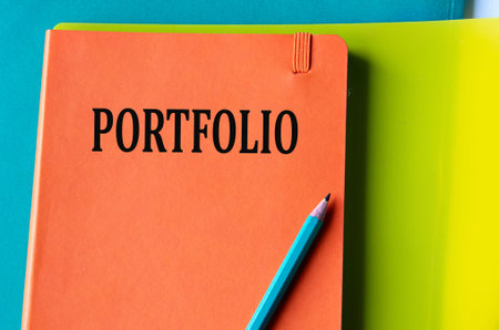 PORTFOLIO - word on an orange notepad on a background of multi-colored folders