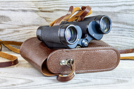 Old binoculars in protective case with wood backgroundの写真素材