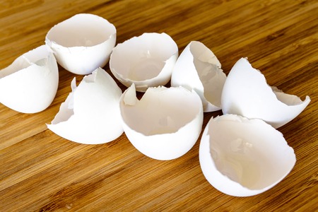 Top view of egg shells on wooden teal green rustic background, flat lay design with egg shells
